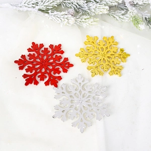 Sparkling red gold and silver snowflake ornaments on festive pine and fabric background