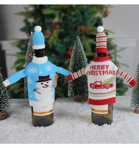 Detail of knitted snowman and red truck wine bottle covers with mini hats for Christmas