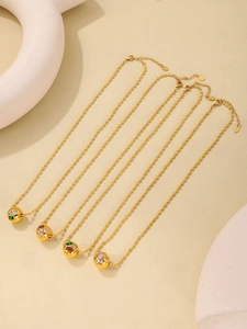 Détail de quatre chaînes à perles dorées avec pendentifs sphériques et zircons