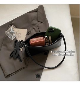 Spacious interior of a black leather crescent underarm bag with mobile and wallet