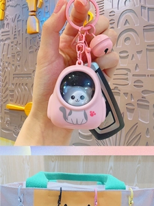 Pink cat in space capsule keychain charm with a matching pink bell for bags and keys