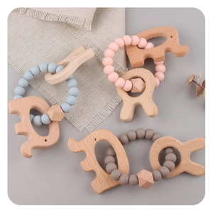 Detail showing colorful silicone beads and beech wood animal teethers on linen background