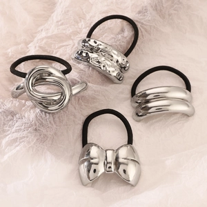 Detailed view of four silver alloy geometric hair ties with textured and polished finishes