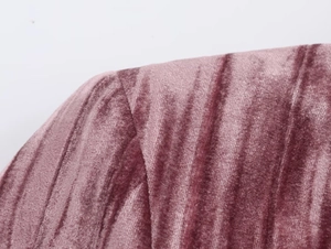 Macro shot of mauve velvet fabric with vertical ribbing and fine stitching detail