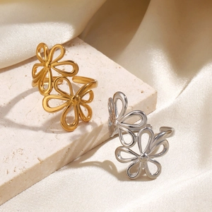 Minimalist stainless steel flower rings in gold and silver finish on silk background