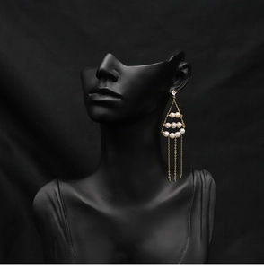 Detailed macro view of long tassel earrings with real pearls and gold plated chain