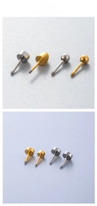 Macro view of gold and silver steel piercing studs with threaded rods and flat round ends