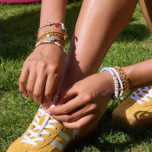Détail de bracelets multicouches en acier inoxydable doré 18K avec perles colorées
