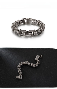 Detail of vintage silver stainless steel bracelet featuring punk wave engraving