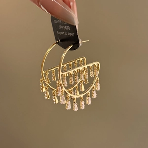 Close-up of 925 silver gold-plated hoop earrings with rectangular cubic zirconia fringe