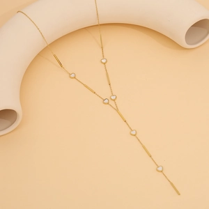 Detailed view of gold Y-shaped necklace featuring small white hearts and metal bar accents