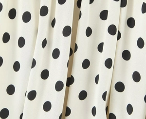 Makroansicht von leichtem weißem Stoff mit klassischem schwarzem Polka-Dot-Print und Textur