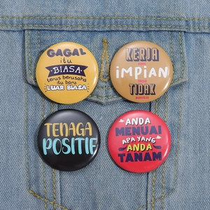 Detailed view of four colorful tinplate badges pinned on denim jacket pocket