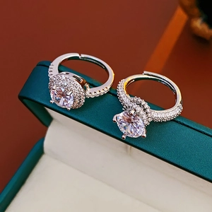 Macro shot of two silver adjustable rings with cubic zirconia on a jewelry box edge