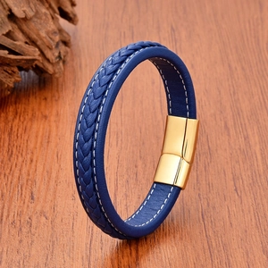 Classic blue braided leather bracelet for men with a polished gold magnetic clasp on wood