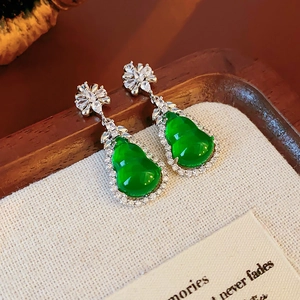 Detail of green resin gourd earrings with zircon floral studs and silver needle base