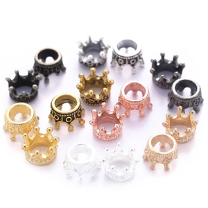Macro shot of crown-shaped alloy jewelry pendants in assorted metallic finishes for DIY making