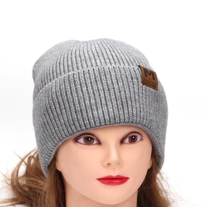 Trendy grey knitted beanie with brown leather M FASHION patch for winter warmth