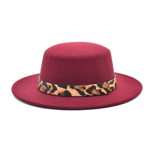 Détail d'un chapeau plat bordeaux à large bord avec bande décorative léopard