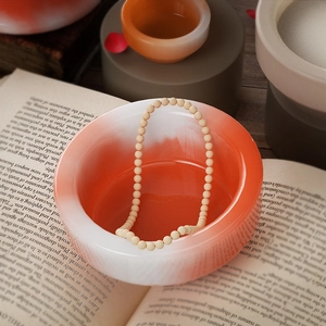 Bovenaanzicht van een zen-harskom met houten kralenketting op open boeken