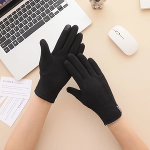 Close-up of black thermal touchscreen gloves with checkered cuffs on office desk