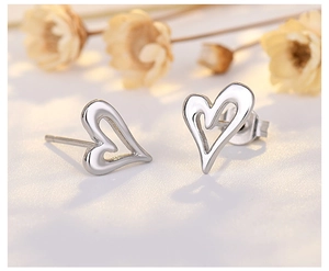 Macro shot of silver hollow heart stud earrings with a polished metallic finish