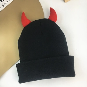 Black knitted beanie featuring red devil horns and cozy texture for winter wear