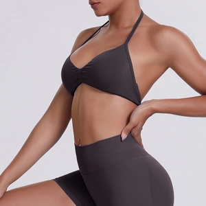Detail of high-waisted seamless biker shorts and halter sports bra in charcoal fabric