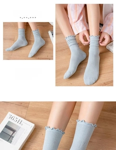 Detailed view of light blue ribbed knit socks with frilled edges and lettuce trim design