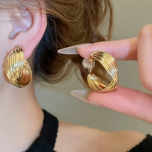 Detailed view of gold twisted hoop earrings with non-pierced clip-on silicone pads