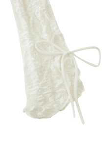 Detailed close-up of delicate white lace sleeve with a dainty white ribbon bow detail
