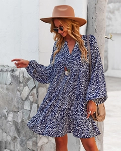 Close-up of the V-neck detail and white polka dot pattern on the navy blue mini dress