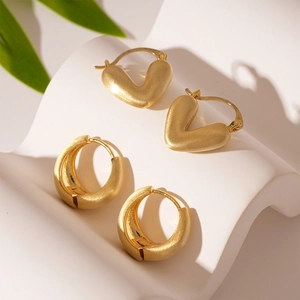 Gold minimalist heart and wide band hoop earring set on an artistic wavy base