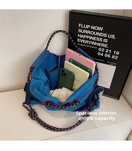 Detail of blue nylon tote bag showing spacious interior with books, tablet and rope handles