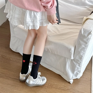 Detail of black cotton socks featuring red heart and follow your heart embroidery
