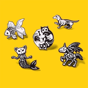 Détails de cinq broches squelettes d'animaux gothiques noir et blanc sur fond jaune