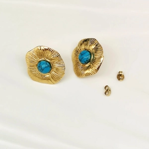 Detail view of gold wavy earrings with blue marble stone inlay and matching backs