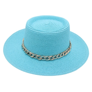 Close-up detail of a stylish light blue French straw hat with gold chain decoration.