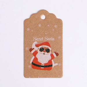 Close-up of Secret Santa Kraft paper gift tag with cartoon Santa and snowflake details
