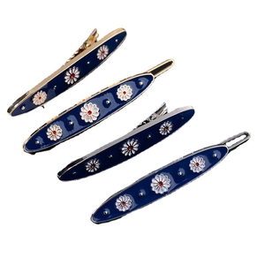 Set of four navy blue enamel daisy hair clips with gold and silver metal edges
