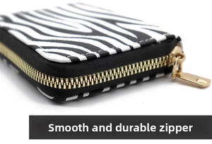 Close-up of zebra pattern wallet detail showing smooth gold metal zipper and stitching