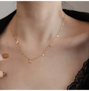 Detail of gold titanium necklace with rectangular crystals and metal fringe on model