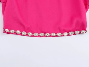 Nahaufnahme von elegantem rosenrotem Stoff mit luxuriöser silberner Strasskette