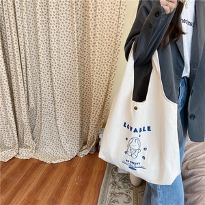 Détail du sac cabas en toile blanc cassé avec lapin bleu mignon et fermeture à pression