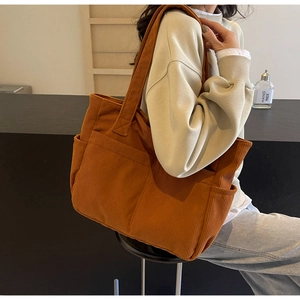 Détail du grand sac cabas en velours côtelé caramel avec poche latérale et bandoulière