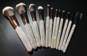 Detailed fan arrangement of 12 luxury makeup brushes with glittering rhinestone handles