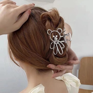 Silver bear metal hair claw clip shown on a model's hair with a minimalist elegant design