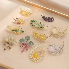 Close-up of magnolia enamel brooches with freshwater pearls and rhinestones on a tray