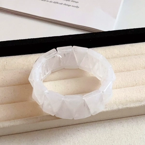 Detail of translucent cream white acrylic triangular beads on minimalist elastic bracelet