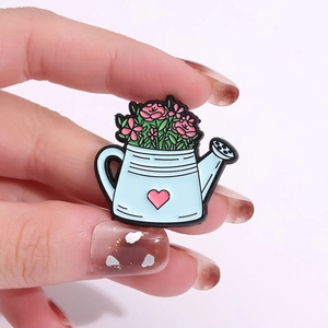 Broche en émail en forme d'arrosoir bleu avec un cœur rose et des fleurs décoratives
